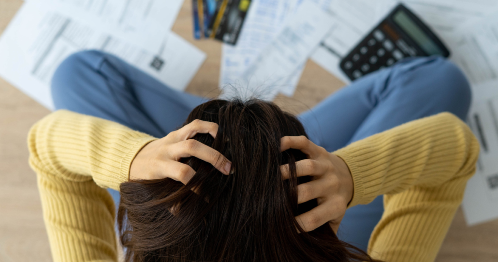 Frustrated woman with lots of bills, invoices in front of her