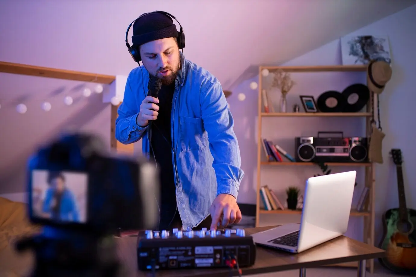 Halbnahe Aufnahme eines Mannes, der in einem Schlafzimmer Musik macht.