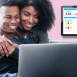 Attractive black couple smiling looking at a laptop screen. Credit report