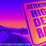 Attention High Debt Ratio sign in purple pink and orange with highway road in the background.