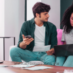 A caucasian man and an ethnic woman with curly hair review their bills in frustration. Paying minimum payment each month.